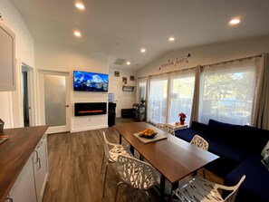 Living room/dining room/kitchenette with big screen doors with balcony access.