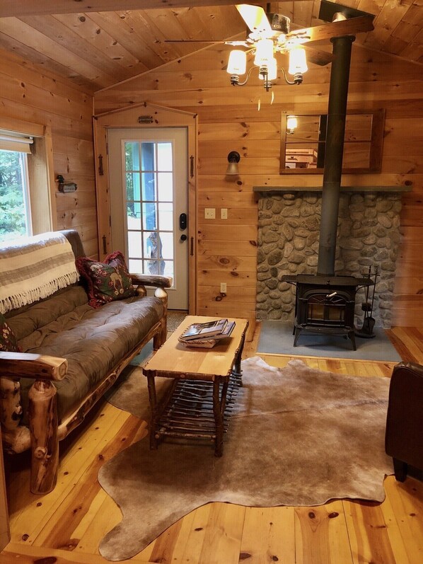 Living room with wood burning stove and futon for additional sleeping. 