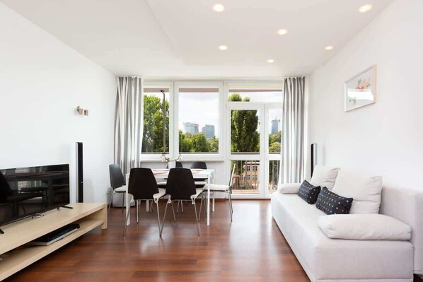 The spacious living room features a comfortable sofa bed and a flat-screen television.