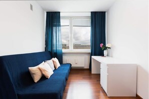 The stylish bedroom includes a comfortable sofa bed and a wardrobe.