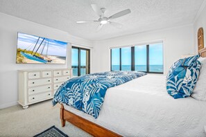 Master bedroom suite with a comfortable king bed, large TV, private balcony access, and ensuite bathroom