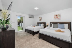 Spacious room with two queen beds and an outdoor view.