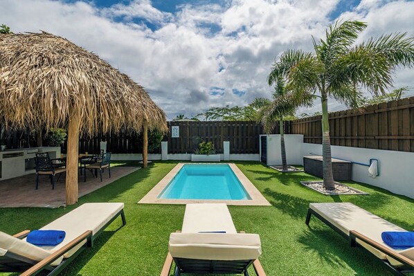 Relaxing backyard retreat featuring a refreshing pool and comfortable lounge chairs.