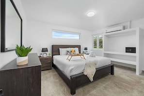 Luxurious bedroom with a comfortable king bed, a built-in AC unit, and a secure safety box.