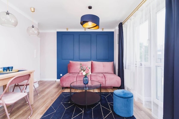 The elegant living room featuring a double sofa bed, perfect for relaxing or sleeping.