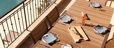 Rez-de-chaussée : la terrasse avec vue sur la piscine en rez de jardin.