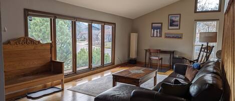 Bright and spacious living room with work area and view of the Boulder Flatirons