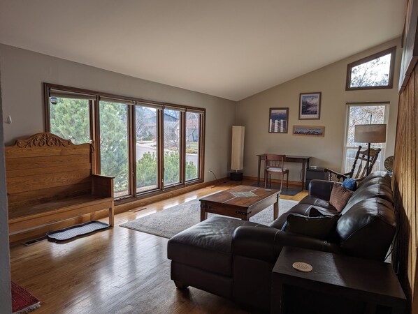 Bright and spacious living room with work area and view of the Boulder Flatirons