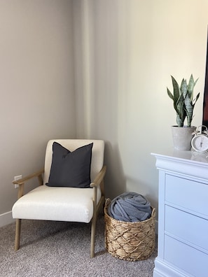 Sitting area in master bedroom, dresser and Roku TV.