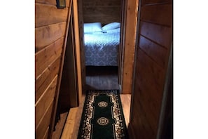 Looking down the hallway past  bathroom to Master bedroom. Storage under stairs.