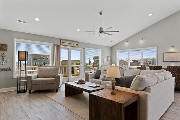 Large, open living area with surrounding windows, lots of natural light, & views