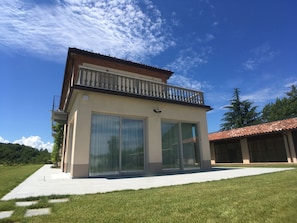 East view : Large sliding windows connect the living room to the outdoor veranda