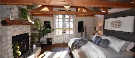 Luxurious master bedroom with double french doors opening to large deck