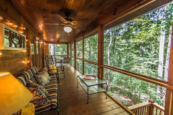 Screened in porch with seating and dining table