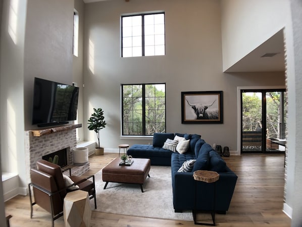 Comfy living room with 75" TV. XL windows bring natural light and nice views