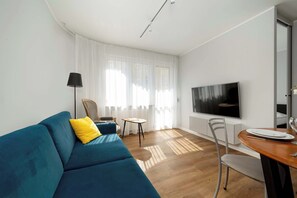 Contemporary living room with smart TV and sofa – Spacious open layout for socializing or watching movies.