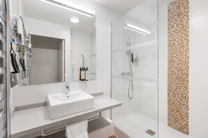 Modern bathroom with a walk-in shower, heated towel rail, and complimentary toiletries to enhance your stay.
