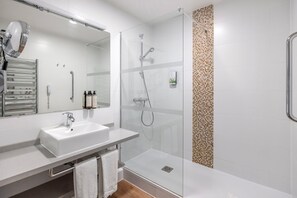 Modern bathroom featuring a sleek walk-in shower, heated towel rail, and complimentary toiletries for your comfort.