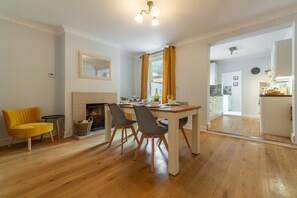 Plum Cottage, Overstrand: Dining room with open fire, looking through to kitchen