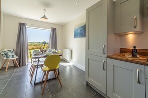 Samphire House, Bodham: Dining area with doors to the garden