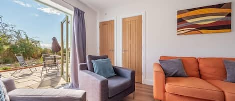 Samphire House: Sitting room with doors open to the garden