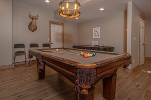 Game On - The full-size pool table takes center stage in the game room, but it’s hardly the only attraction; there’s also an arcade game and a TV.