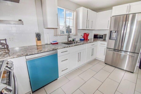 Modern appliances, cookware, and a dining area for home-cooked meals.