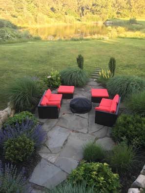 Outdoor seating area near the pond with fire pit. 