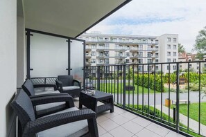 Spacious balcony with outdoor furniture. 