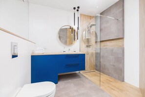 Bathroom with washing machine and towels. 
