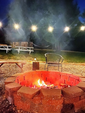 Enjoy the firepit surrounded by lights in the back yard. Seating for 10