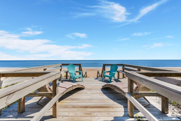 Large sun deck with built-in seating and walkway to pristine private beach