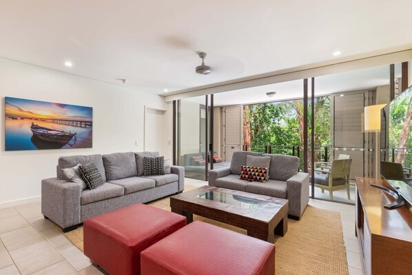 The breezy living area is set with two comfortable lounges fronting a smart TV.  