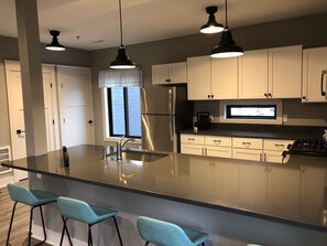 Full-sized kitchen stocked with all essential dishes and utensils.