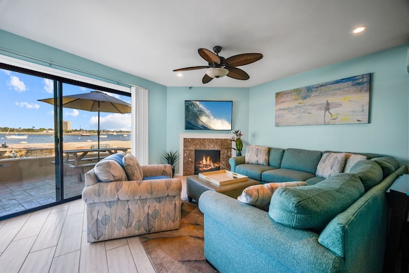 View of the living room and view of the bay outside from your big slider window. (Disclaimer: fireplace is not functional)