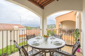 Alfresco dining setup on a cozy balcony with scenic views.