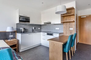 A spacious dining area merges with a modern kitchen, ideal for family meals.