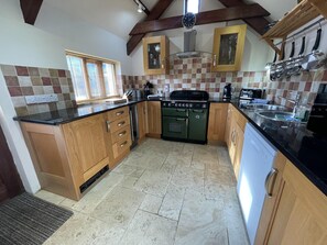 Comprehensively fitted kitchen with electric range cooker and induction hob, full height fridge freezer, microwave and coffee maker.