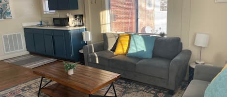 The living room features an eat-in dining space plus living space, a flat-screen TV, and in-unit laundry.