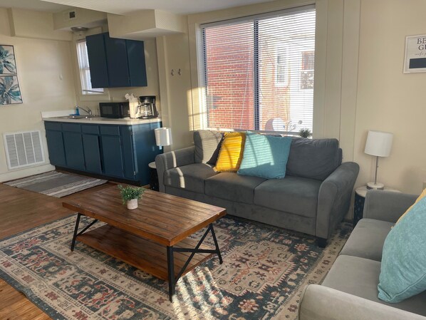 The living room features an eat-in dining space plus living space, a flat-screen TV, and in-unit laundry.