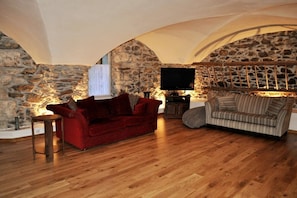 The spacious lounge provides a stunning place to relax, with comfortable sofas, and french doors to the garden.