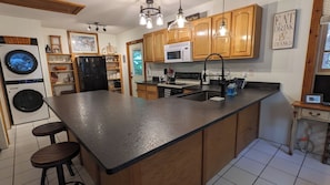 Well-equipped kitchen with full size refrigerator, stove, and new washer/dryer