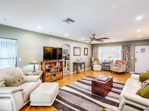 Main living room. Hardwood floors, view of front yard and pool out back. 