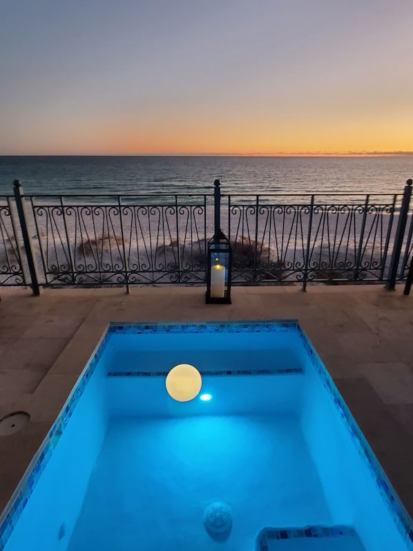 Pool with sunset on the first floor overlooking beach.