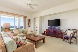Spacious ocean view living area with lanai access and flat screen TV.