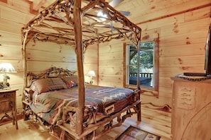 Master bedroom with gorgeous custom, tree branch queen canopy bed and smart TV.