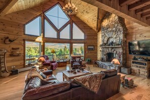 The great room with Adirondack mountain views, a custom fireplace, big screen tv