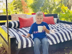Full size yard swing in the back yard is a great place for morning coffee