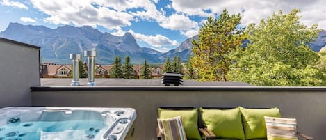 Top floor south-facing deck with 4 person hot tub, comfy outdoor seating and gas BBQ