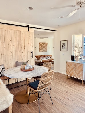 Sun-drenched dining space with barn door. Table seats five to six.